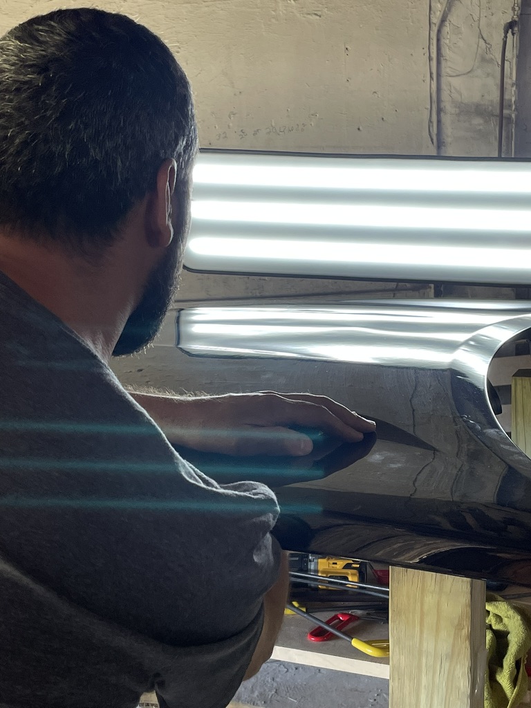 Technician massaging a panel back to contour under PDR lighting