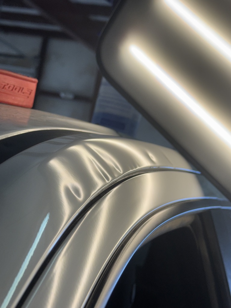 Several roof-edge dents revealed beneath a PDR inspection light