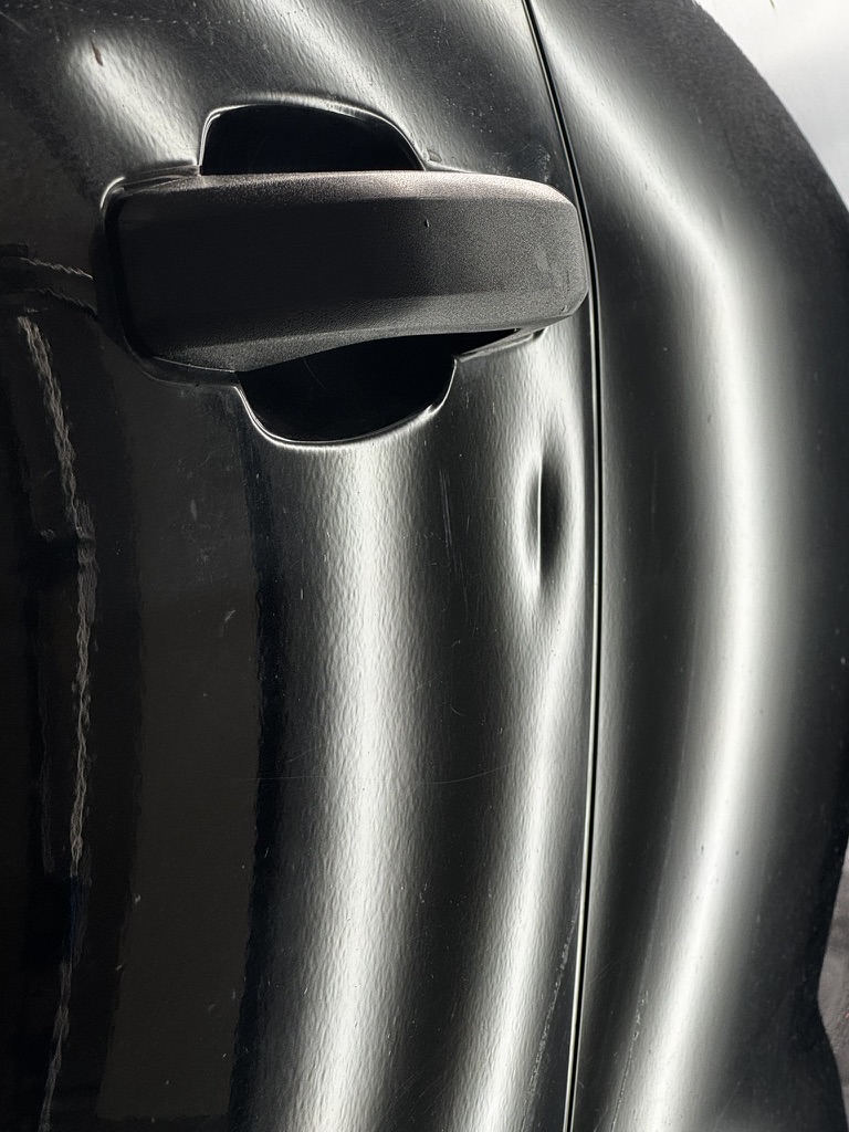 Door ding beside a vehicle door handle