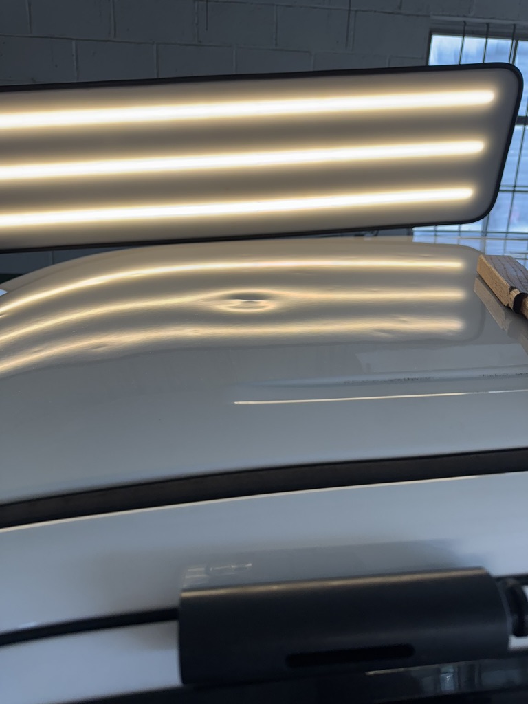 Single roof dent beneath a warm PDR reflection board