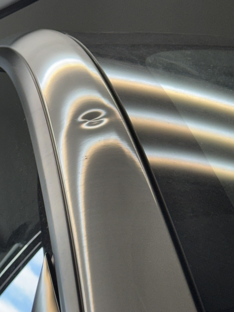 Sharp dent on a silver roof rail under PDR reflection lighting
